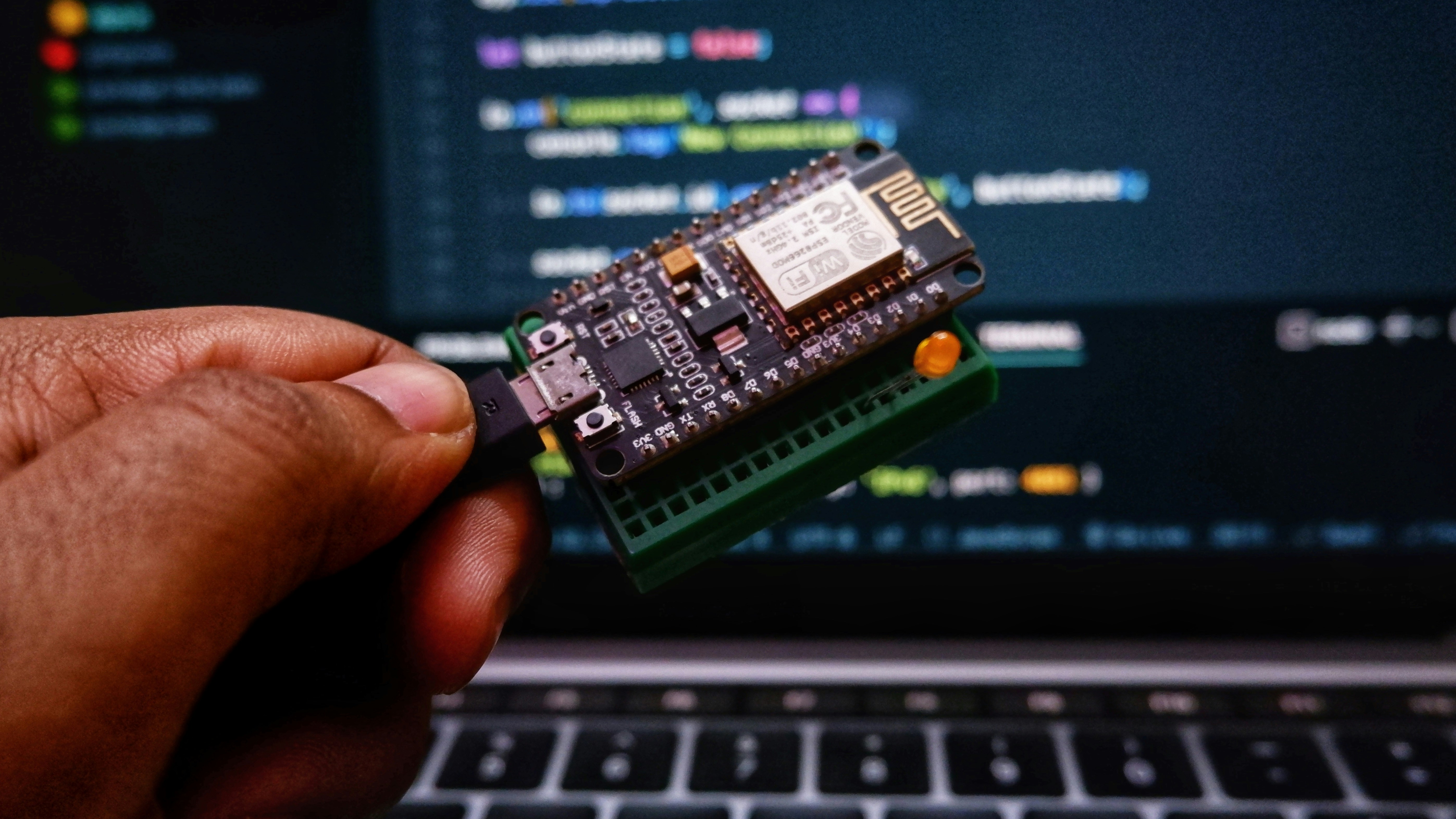 IoT Wi-Fi microcontroller board in front of code